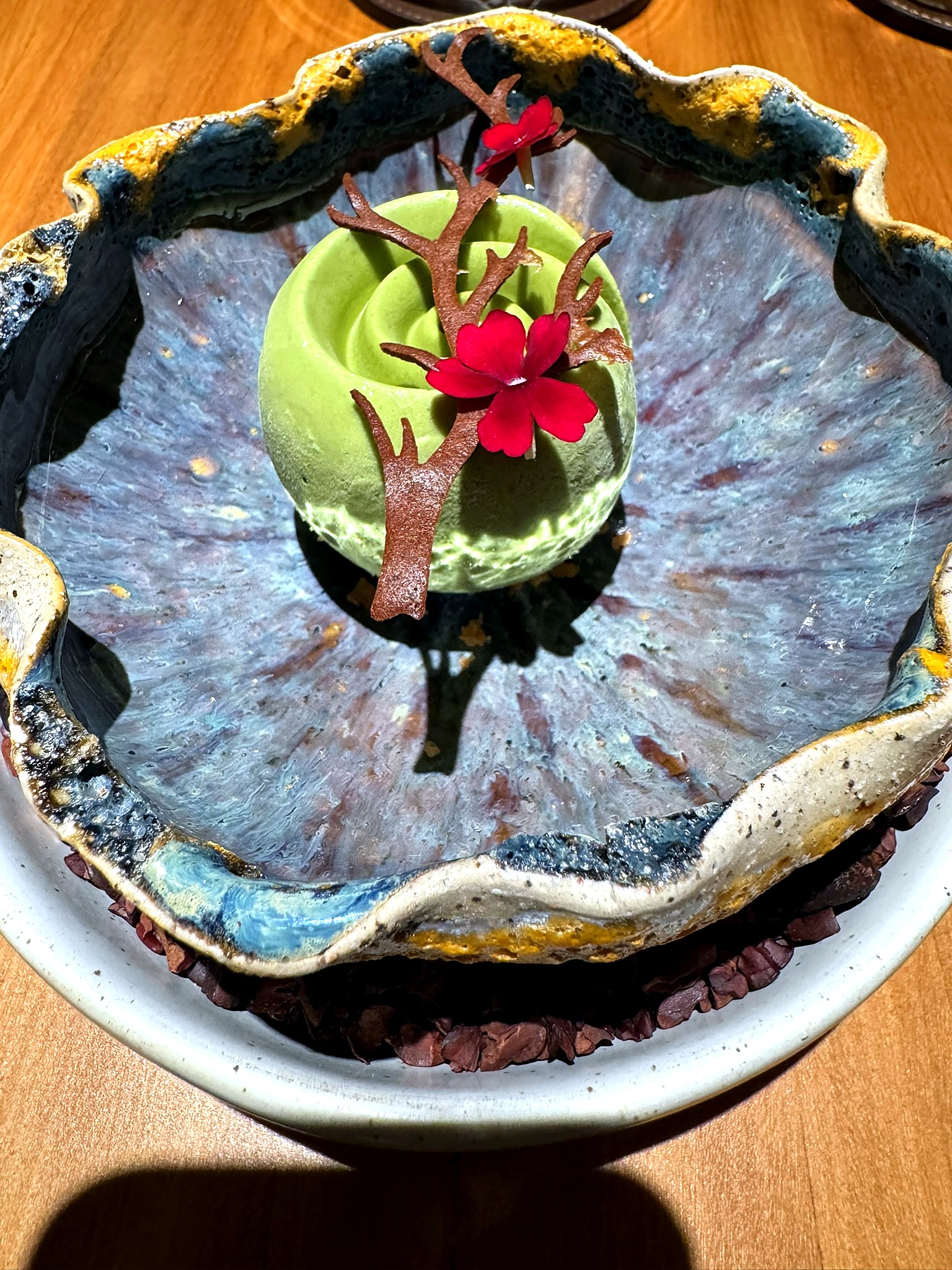 チョコレートの装飾を添えた芸術的なグリーンムースのデザート